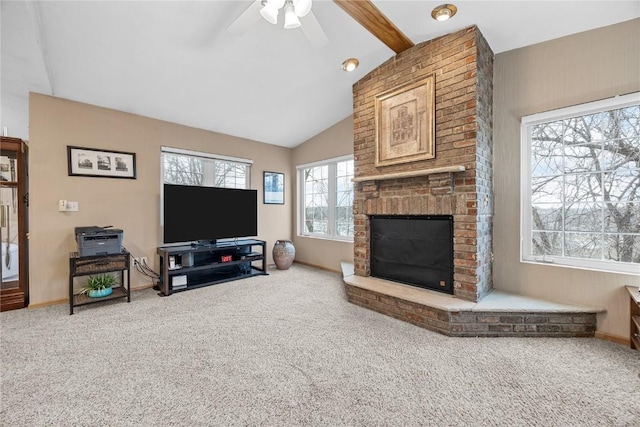 carpeted living area featuring vaulted ceiling with beams, a brick fireplace, baseboards, and a ceiling fan