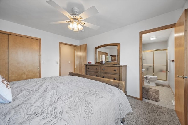 bedroom with ceiling fan, ensuite bathroom, light carpet, baseboards, and a closet