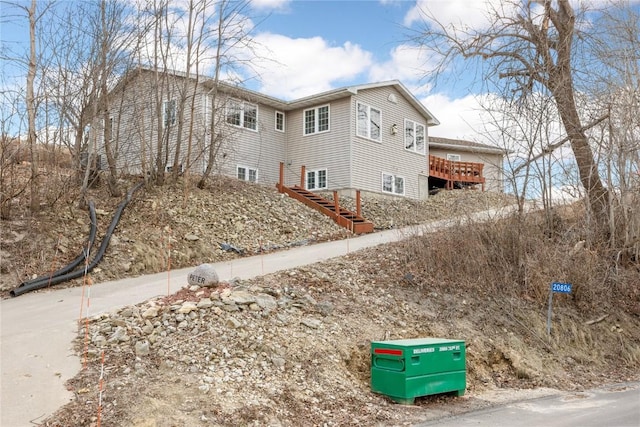 view of property exterior with stairs and a wooden deck