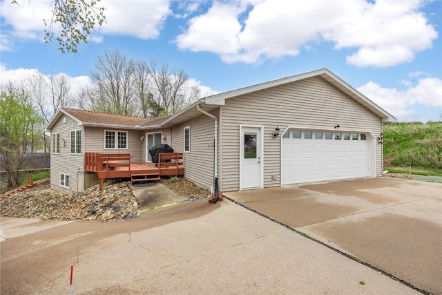 single story home featuring a wooden deck, an attached garage, and driveway