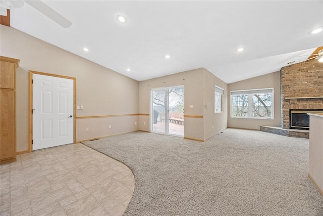 unfurnished living room featuring plenty of natural light, a ceiling fan, and vaulted ceiling