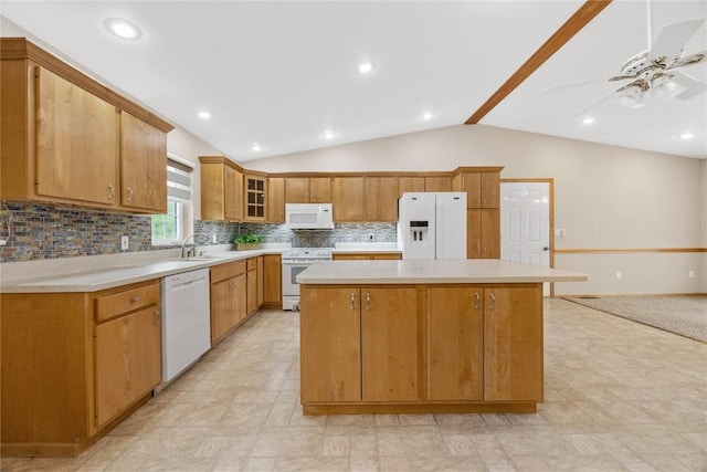 kitchen featuring a kitchen island, tasteful backsplash, vaulted ceiling, light countertops, and white appliances