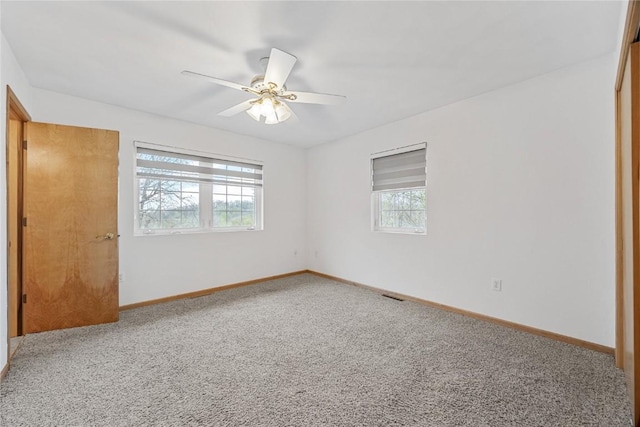 unfurnished bedroom with carpet flooring, baseboards, and multiple windows