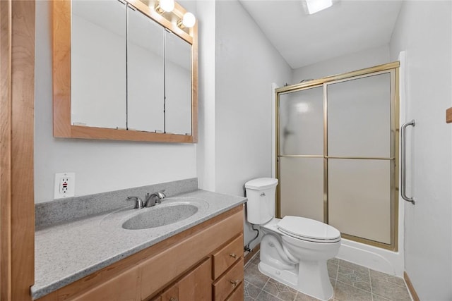 bathroom with toilet, a shower stall, tile patterned flooring, and vanity