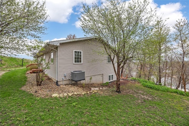 view of side of home with central air condition unit and a lawn