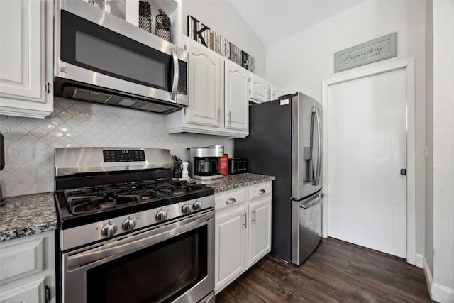 kitchen with lofted ceiling, dark wood-type flooring, white cabinetry, appliances with stainless steel finishes, and backsplash