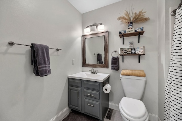 bathroom featuring toilet, visible vents, baseboards, and vanity