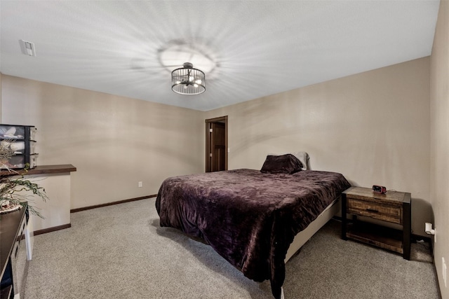 carpeted bedroom featuring a notable chandelier, visible vents, and baseboards