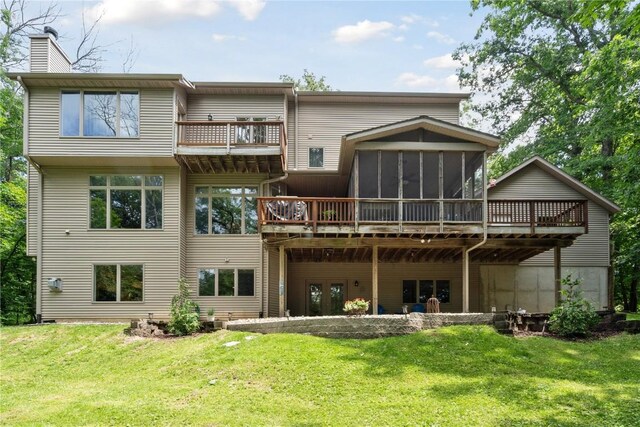 rear view of house with a sunroom, a yard, and a chimney