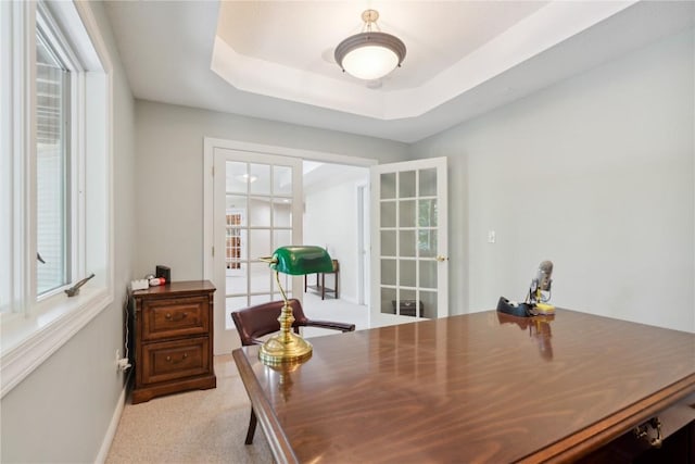 office area with french doors, a raised ceiling, light carpet, and baseboards