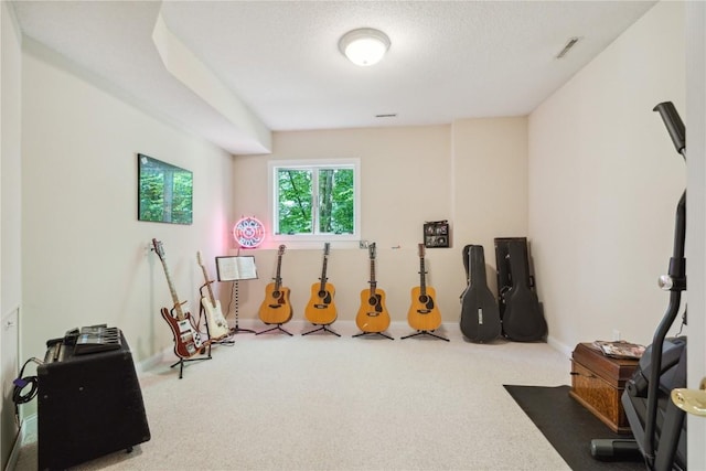 exercise area with a textured ceiling, carpet, visible vents, and baseboards