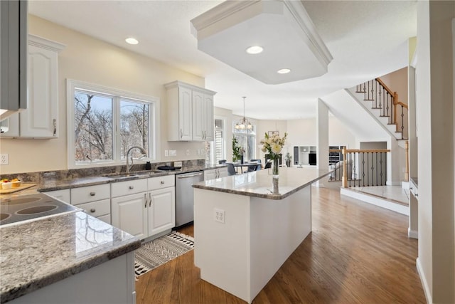 kitchen with dark wood finished floors, white cabinetry, dishwasher, and a sink