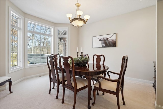 dining room with a healthy amount of sunlight, an inviting chandelier, light carpet, and baseboards