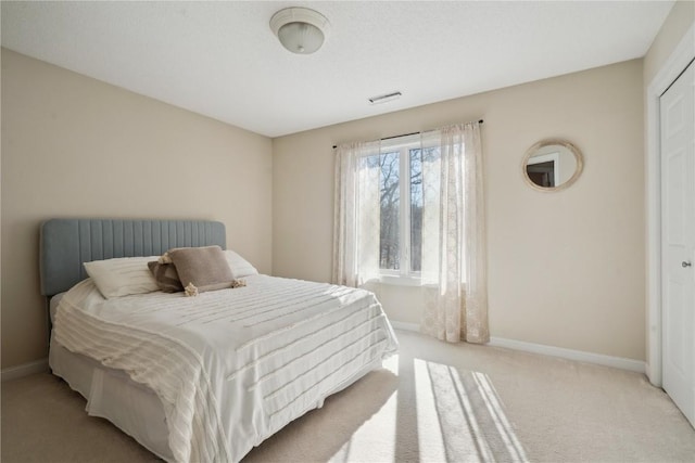 bedroom with light carpet and baseboards