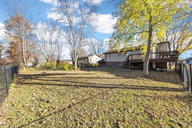 view of yard with a wooden deck, stairs, and a fenced backyard