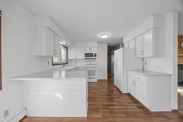 kitchen with light countertops, a peninsula, white appliances, white cabinetry, and a baseboard radiator