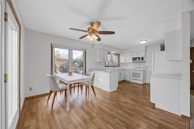 dining space with light wood-style floors, baseboards, and ceiling fan