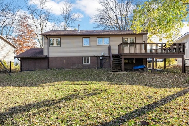 rear view of house featuring a deck, stairway, a yard, and fence