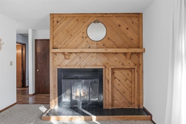 details with baseboards, carpet floors, and a glass covered fireplace