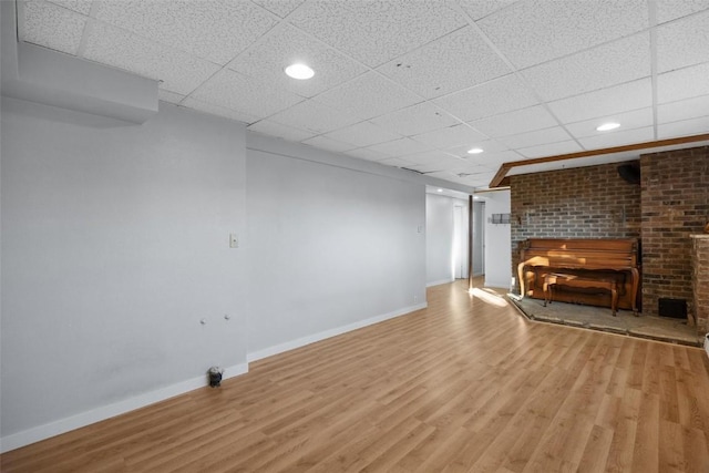 unfurnished living room with recessed lighting, a paneled ceiling, baseboards, and wood finished floors