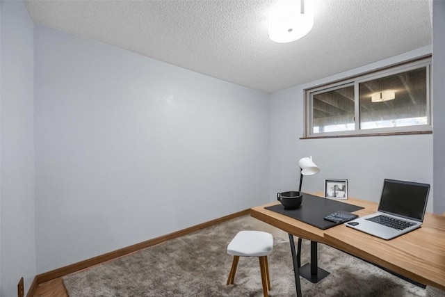 office space featuring a textured ceiling, baseboards, and carpet floors