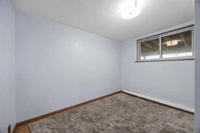 spare room featuring baseboard heating, carpet flooring, a textured ceiling, and baseboards