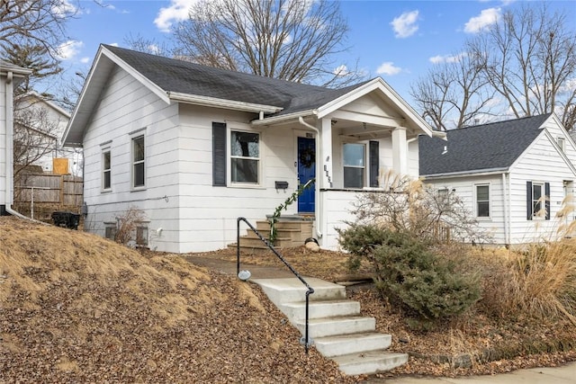 bungalow-style home with roof with shingles