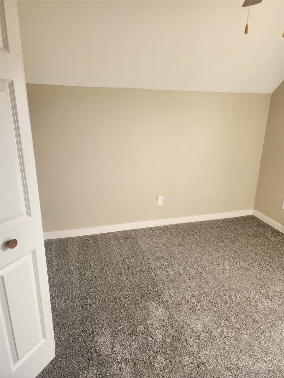 unfurnished room featuring carpet floors, baseboards, and vaulted ceiling