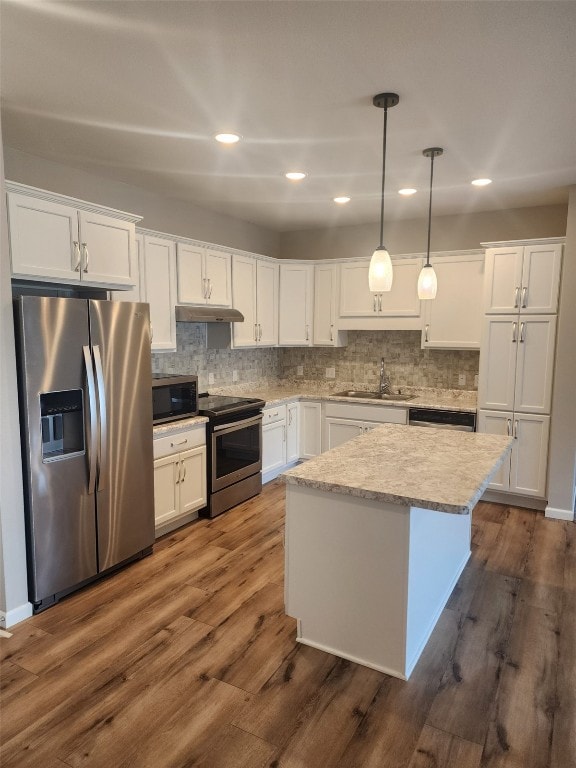 kitchen with stainless steel appliances, a sink, white cabinetry, and under cabinet range hood