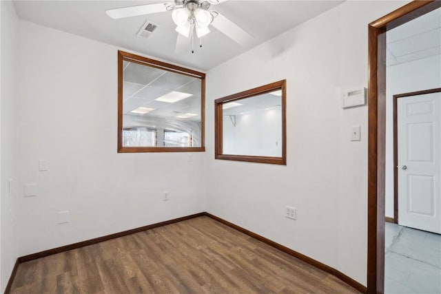 spare room with light wood-style floors, visible vents, baseboards, and a ceiling fan