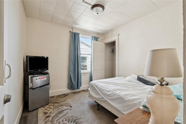 carpeted bedroom with baseboards and a textured wall