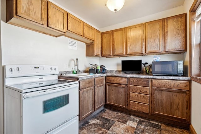 kitchen featuring brown cabinetry, black microwave, a sink, and electric range