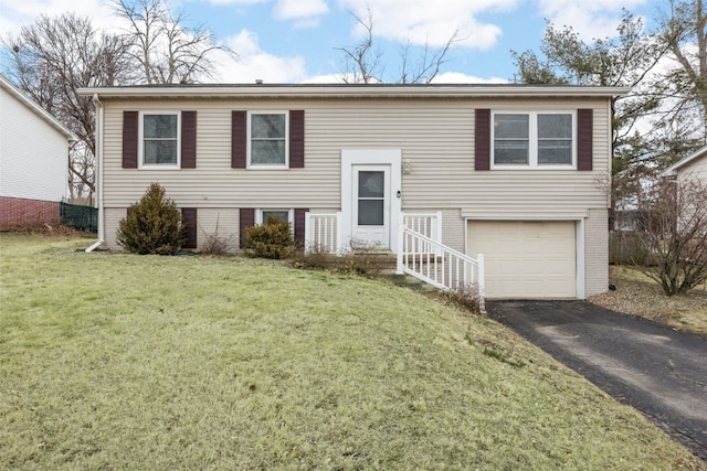 split foyer home with driveway, brick siding, a garage, and a front yard