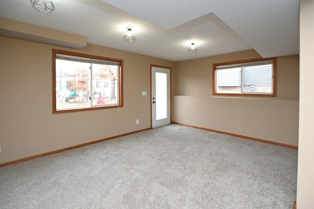 carpeted empty room featuring baseboards