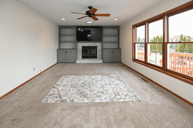 unfurnished living room featuring baseboards, visible vents, light colored carpet, a fireplace, and recessed lighting