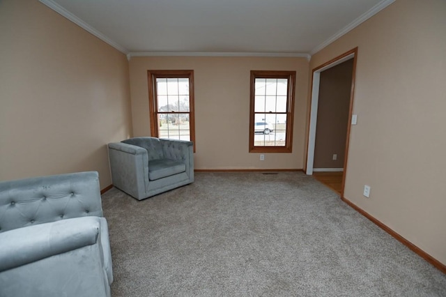 sitting room with carpet flooring, crown molding, and baseboards