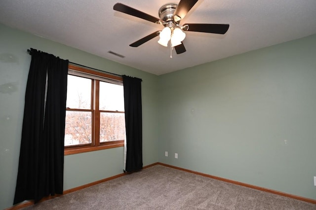 empty room featuring carpet floors, visible vents, and baseboards