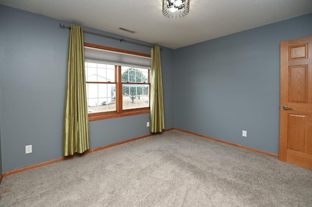 carpeted empty room featuring visible vents and baseboards