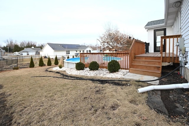 view of yard with a fenced in pool, a residential view, fence, and a deck