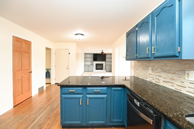 kitchen with light wood-style flooring, a peninsula, black dishwasher, blue cabinetry, and decorative backsplash