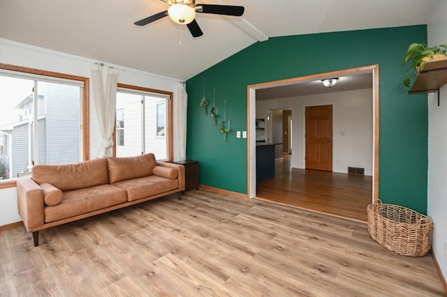 living room with light wood finished floors, baseboards, visible vents, a ceiling fan, and lofted ceiling with beams