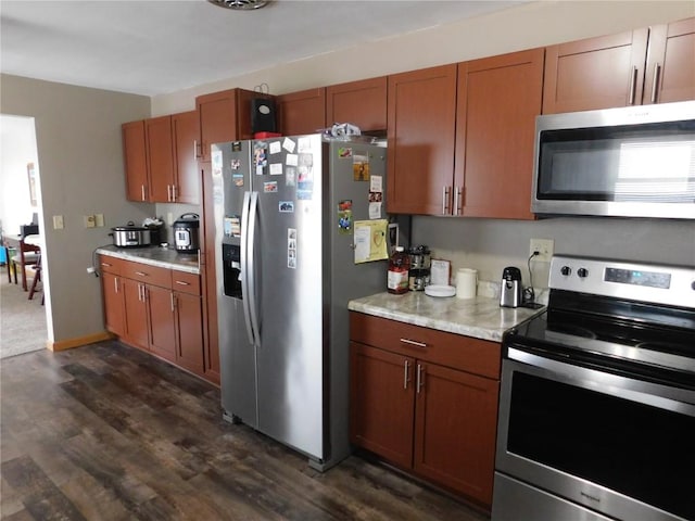 954 Monroe Ave, Tipton, IA 52772 - kitchen with stainless steel appliances, dark wood-type flooring, light countertops, and brown cabinets