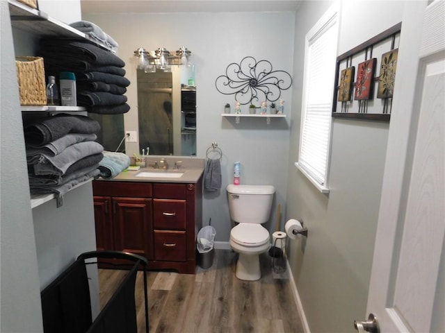 954 Monroe Ave, Tipton, IA 52772 - full bathroom with wood finished floors, toilet, a shower with door, baseboards, and vanity