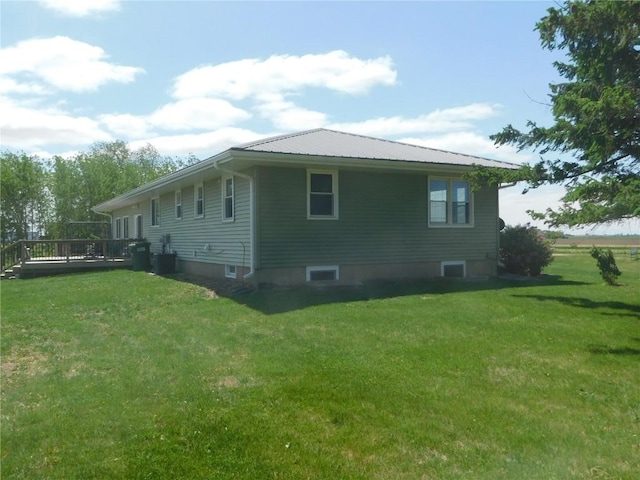 954 Monroe Ave, Tipton, IA 52772 - view of side of property with a yard, a wooden deck, and metal roof