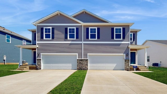 view of front of home featuring a garage, stone siding, central AC unit, and concrete driveway