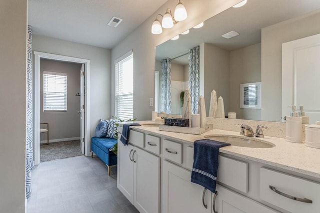 bathroom featuring visible vents, vanity, and baseboards