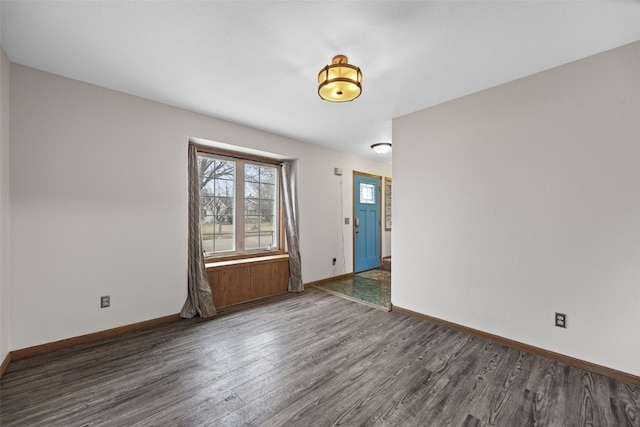 empty room featuring baseboards and wood finished floors