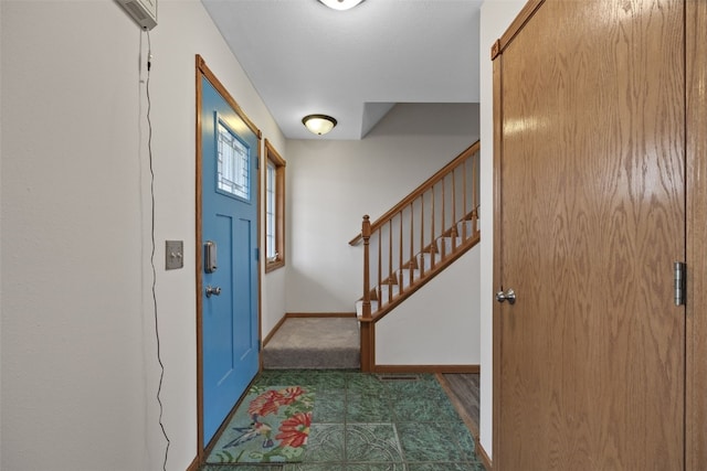 foyer with baseboards and stairs