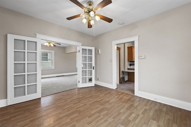 unfurnished room with ceiling fan, french doors, wood finished floors, and baseboards