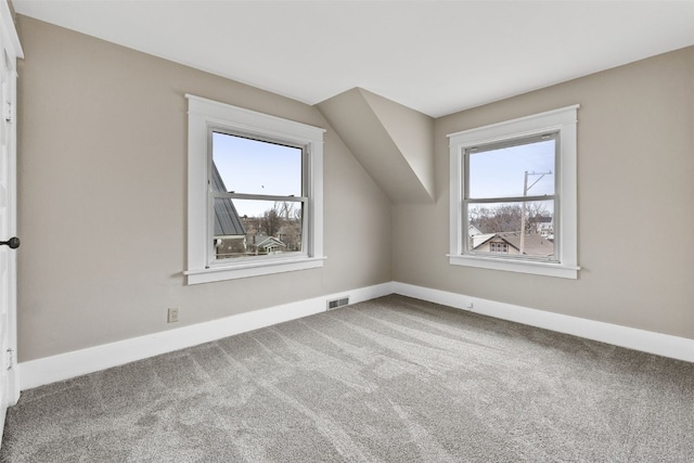 bonus room with baseboards, visible vents, vaulted ceiling, and carpet flooring